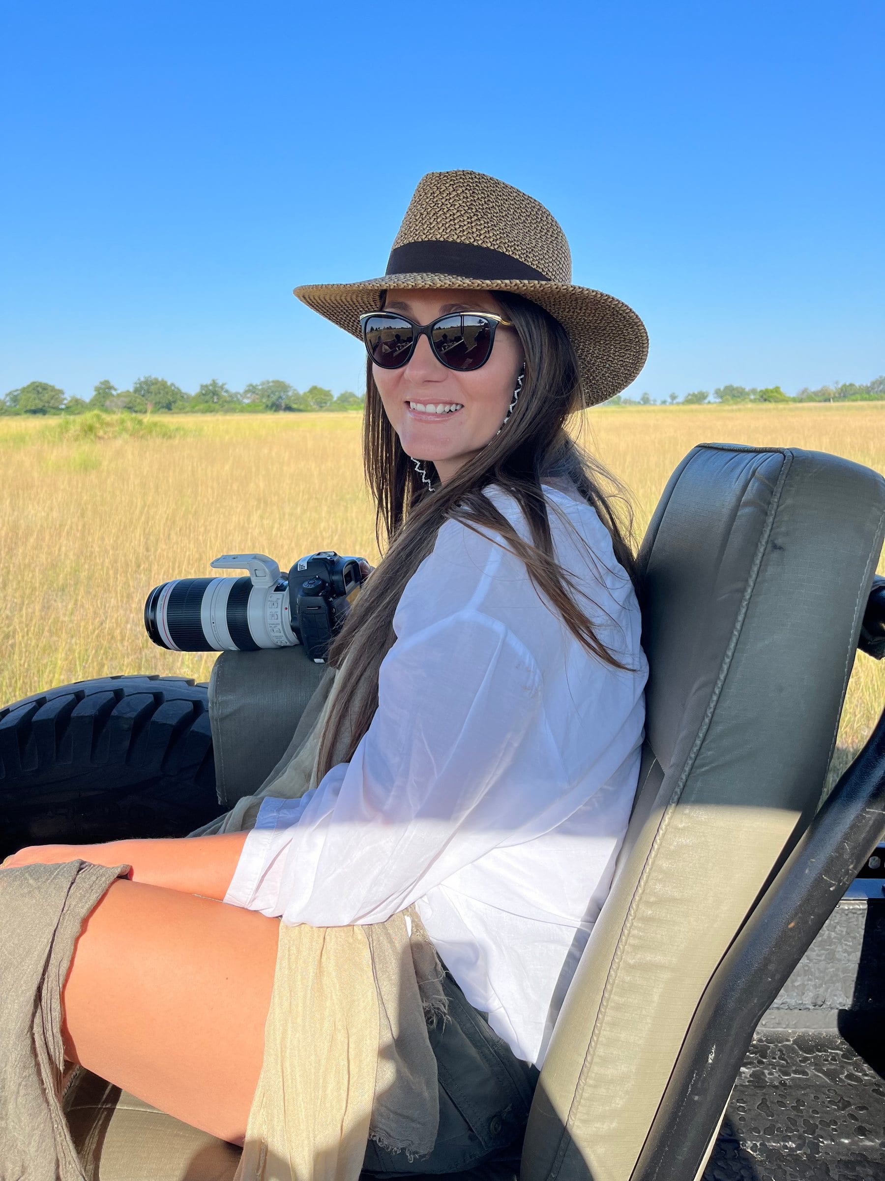 Danielle in the front seat of an open safari vehicle with her camera