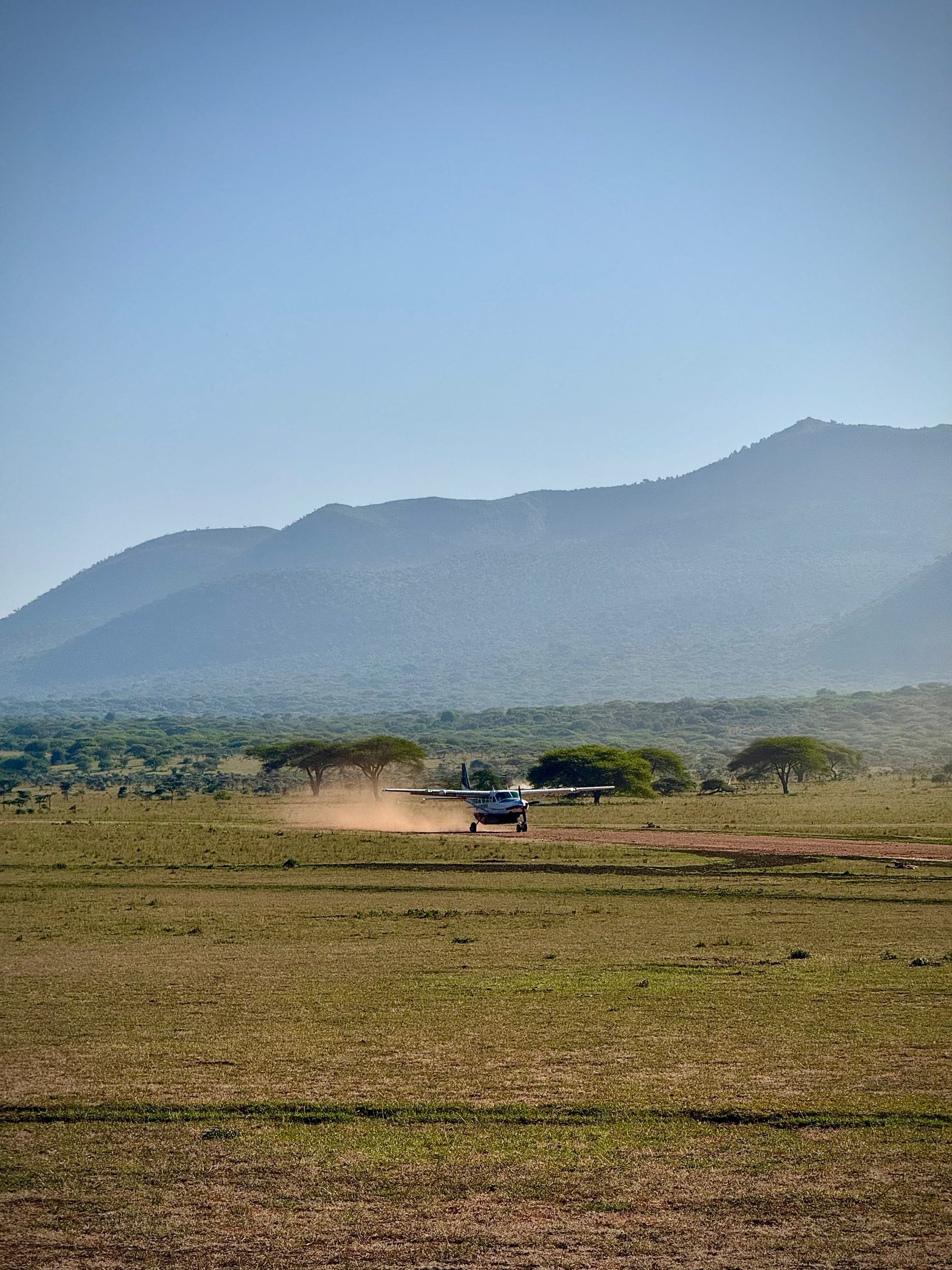 A small bush plane touching down on a dirt airstrip