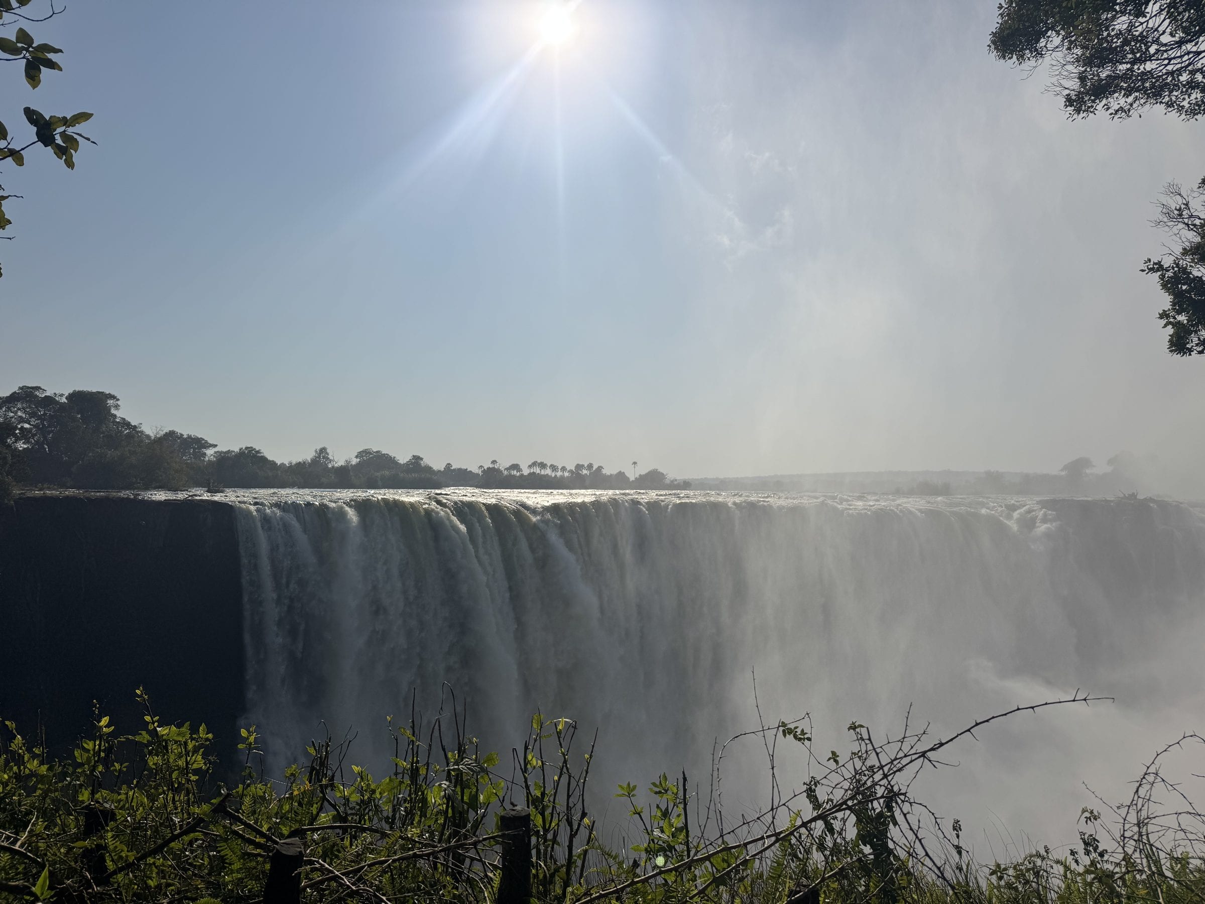 Victoria Falls in full spray under a bright sun